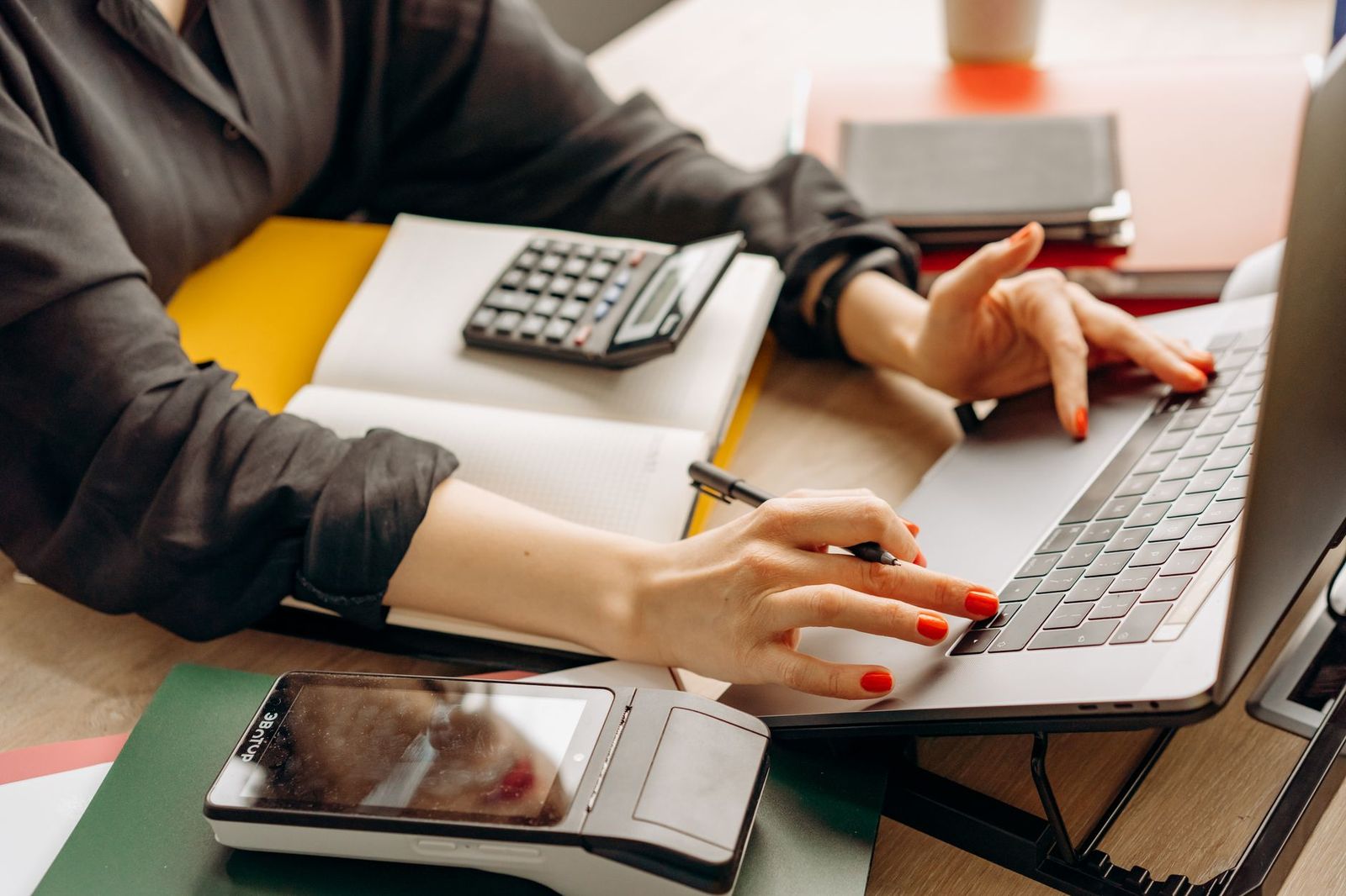 Manos de un contador trabajando con calculadora y documentos