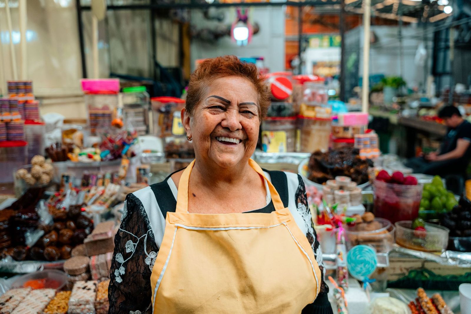 Dueña de un almacén sonriendo en su negocio